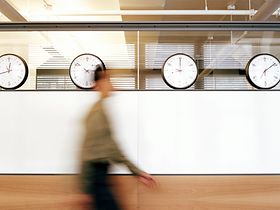 Frau rennt an Uhren vorbei