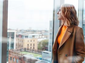 Frau schaut aus dem Fenster