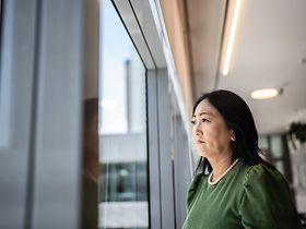 Frau schaut aus Fenster