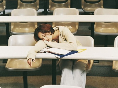 Frau schläft mit Kopf auf Tisch