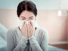 Frau schnäuzt sich die Nase (1)
