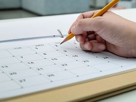 Frau schreibt in den Kalender