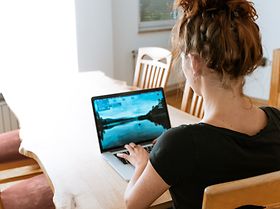 Frau sitzt am Küchentisch im Homeoffice