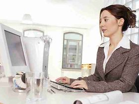 Frau sitzt im Buero am Computer