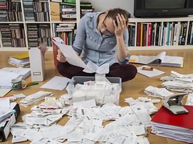 Frau sortiert überfordert Rechnungen