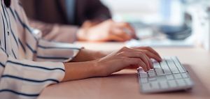 Frau tippt auf Tastatur