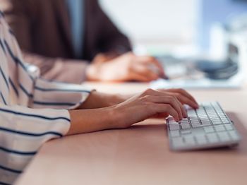 Frau tippt auf Tastatur