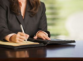 Frau unterschreibt Vertrag oder notiert sich etwas