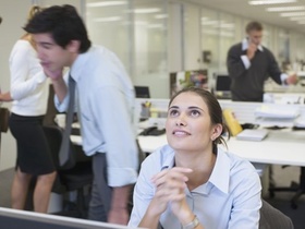 Frau vor Computer schaut nach oben
