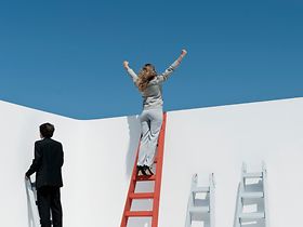 Frauen, die über eine Mauer klettern
