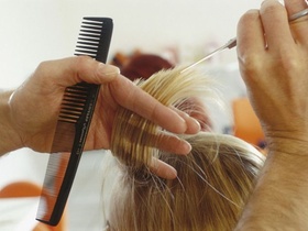 Friseur schneidet Haare, Detail Haende