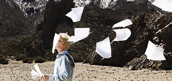 Gegenwind Mann Blätter Papier Landschaft karg