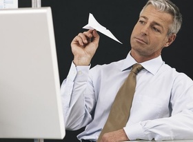 Gelangweilter Mann mit Papierflieger