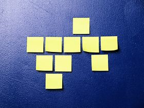 Gelbe Post-it Zettel kleben an blauer Wand