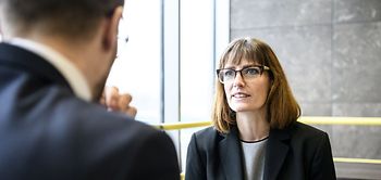 Geschäftsfrau erklärt Mann und gestikuliert