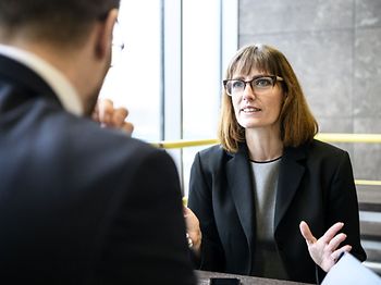 Geschäftsfrau erklärt Mann und gestikuliert