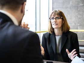 Geschäftsfrau erklärt Mann und gestikuliert