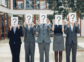 Business people with question mark on placards