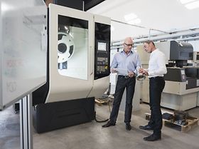 Geschäftsmänner kontrollieren große Maschine in Fabrik