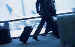 Geschäftsmann am Flughafen laufend mit Gepäck