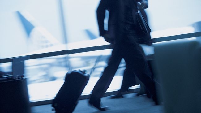 Geschäftsmann am Flughafen laufend mit Gepäck