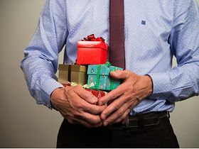 Geschäftsmann mit Geschenken im Arm