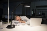 Geschäftsmann schläft nachts an Schreibtisch