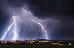 Gewitterfront mit Blitzen über Stadt
