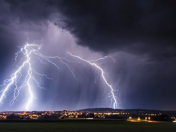 Gewitterfront mit Blitzen über Stadt