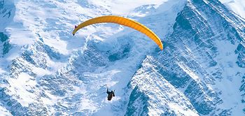 Gleitschirmflieger vor Montblanc-Massiv