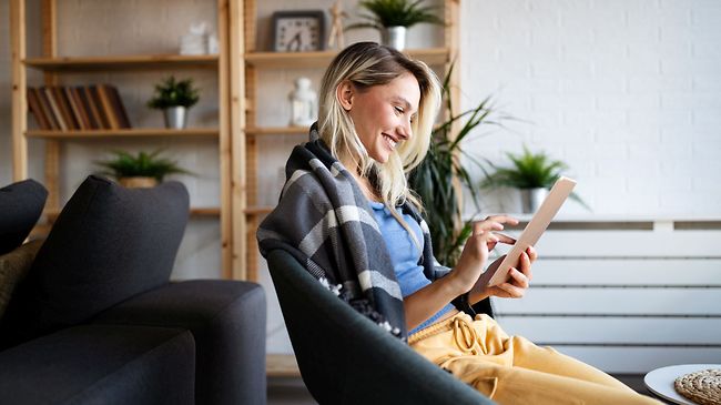 glückliche Frau am Tablet im Loft-Wohnung