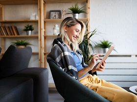 glückliche Frau am Tablet im Loft-Wohnung