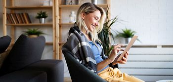 glückliche Frau am Tablet im Loft-Wohnung