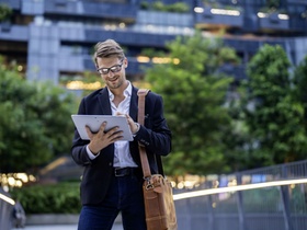 Portrait of businessman in glasses holding tablet