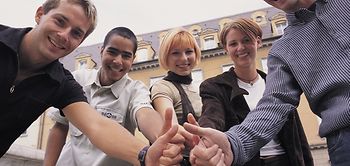 Gruppe junger Menschen halten Daumen hoch