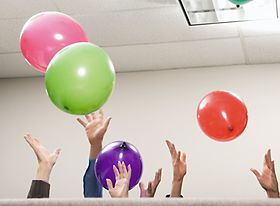 Hände die bunte Luftballons in die Höhe werfen