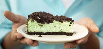 Hände halten ein Stück Kuchen