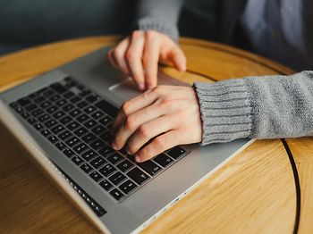 Hände mit Strickpulli am tippen