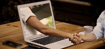 Händedruck durch Laptop