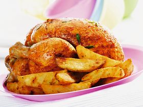 Halbes Brathaehnchen und Pommes frites auf Teller