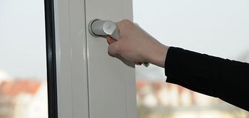 Hand am Fenstergriff