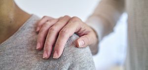 Hand auf Schulter