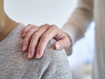 Hand auf Schulter