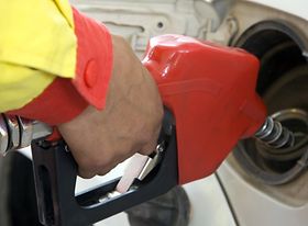 Hand einer Mitarbeiters der ein Auto betankt