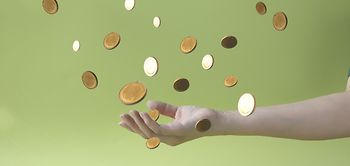 Hand fängt fliegende Münzen