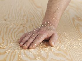 Hand liegt auf Holzfläche