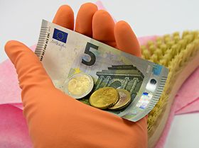 Hand mit Geldschein und Münzen