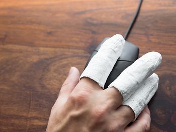 Hand mit Gips an der Maus