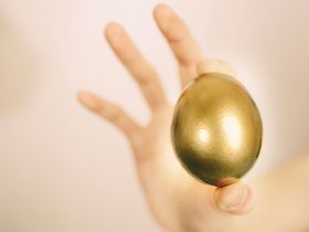 Hand mit goldenem Ei