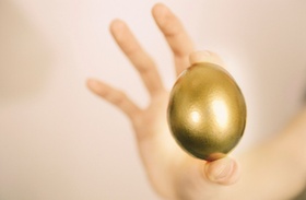 Hand mit goldenem Ei